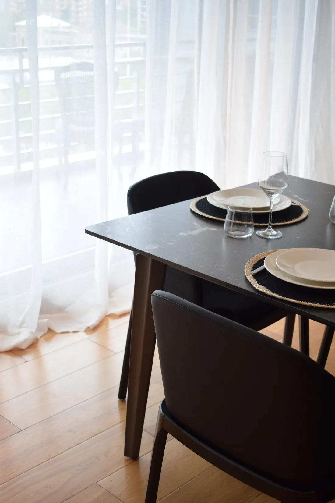La mesa del comedor de Al Río, puesta, junto a las cortinas livianas