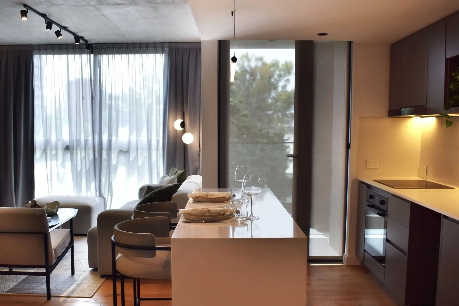 Cocina integrada al living con muebles oscuros y mesada clara