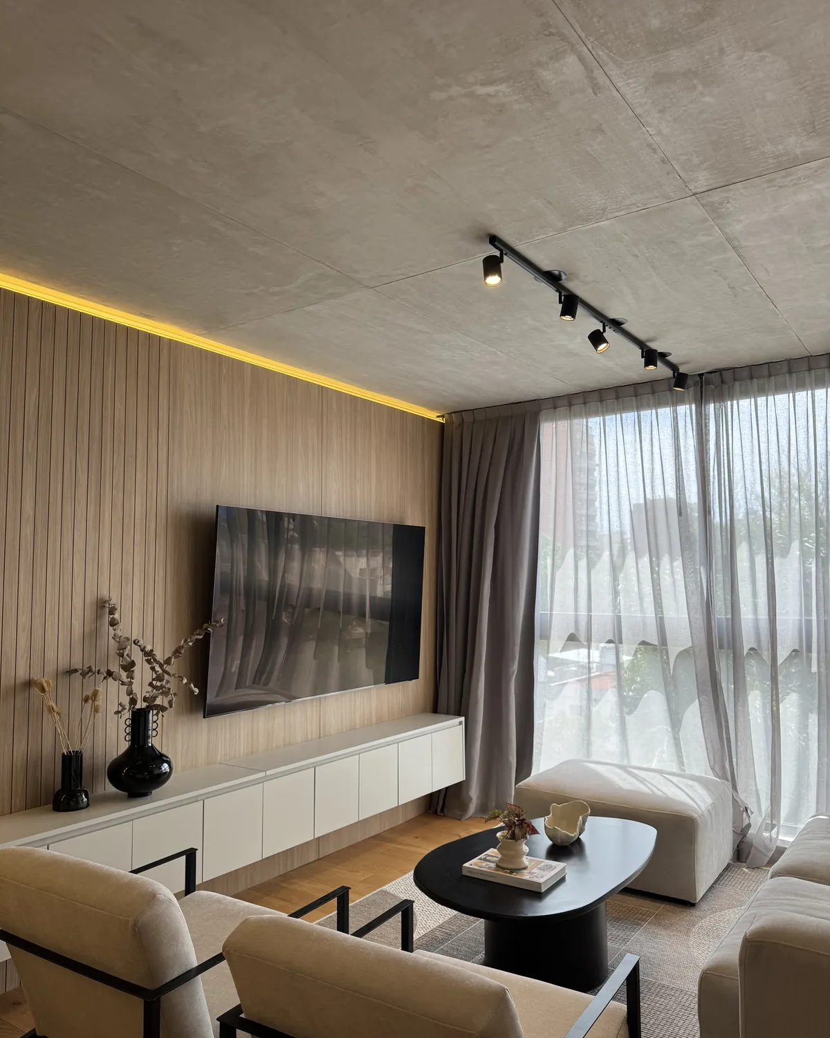 Living con revestimiento de madera, TV integrada y mueble suspendido